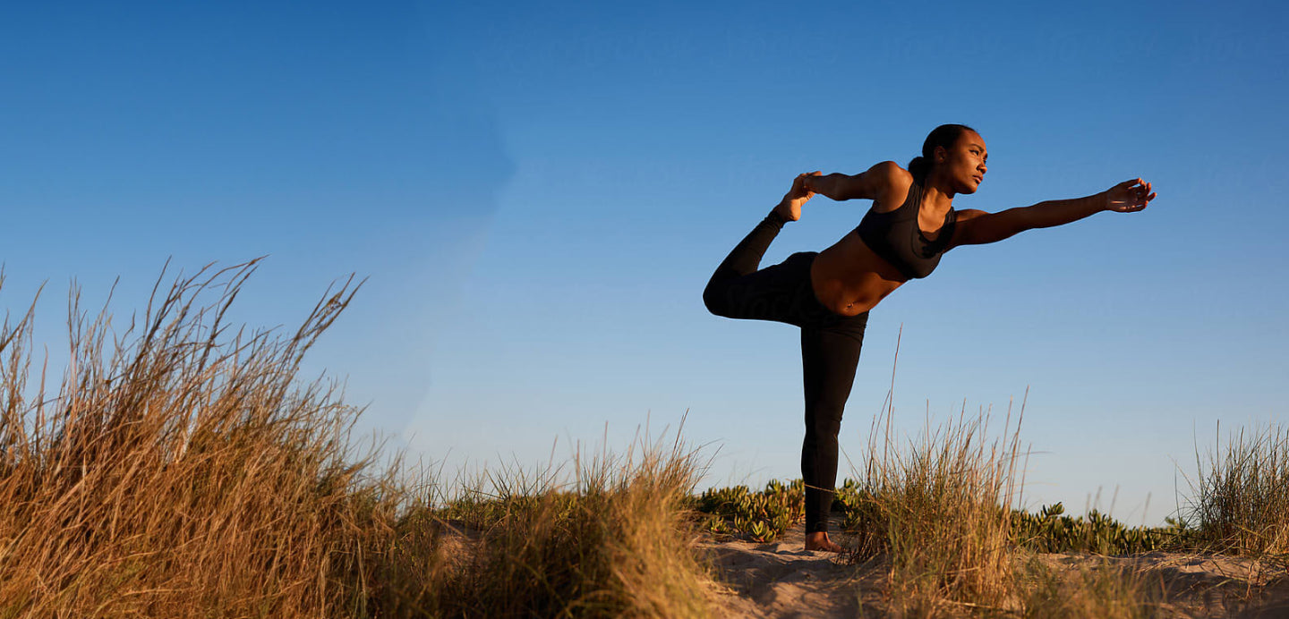 Woman standing near a beach stretching