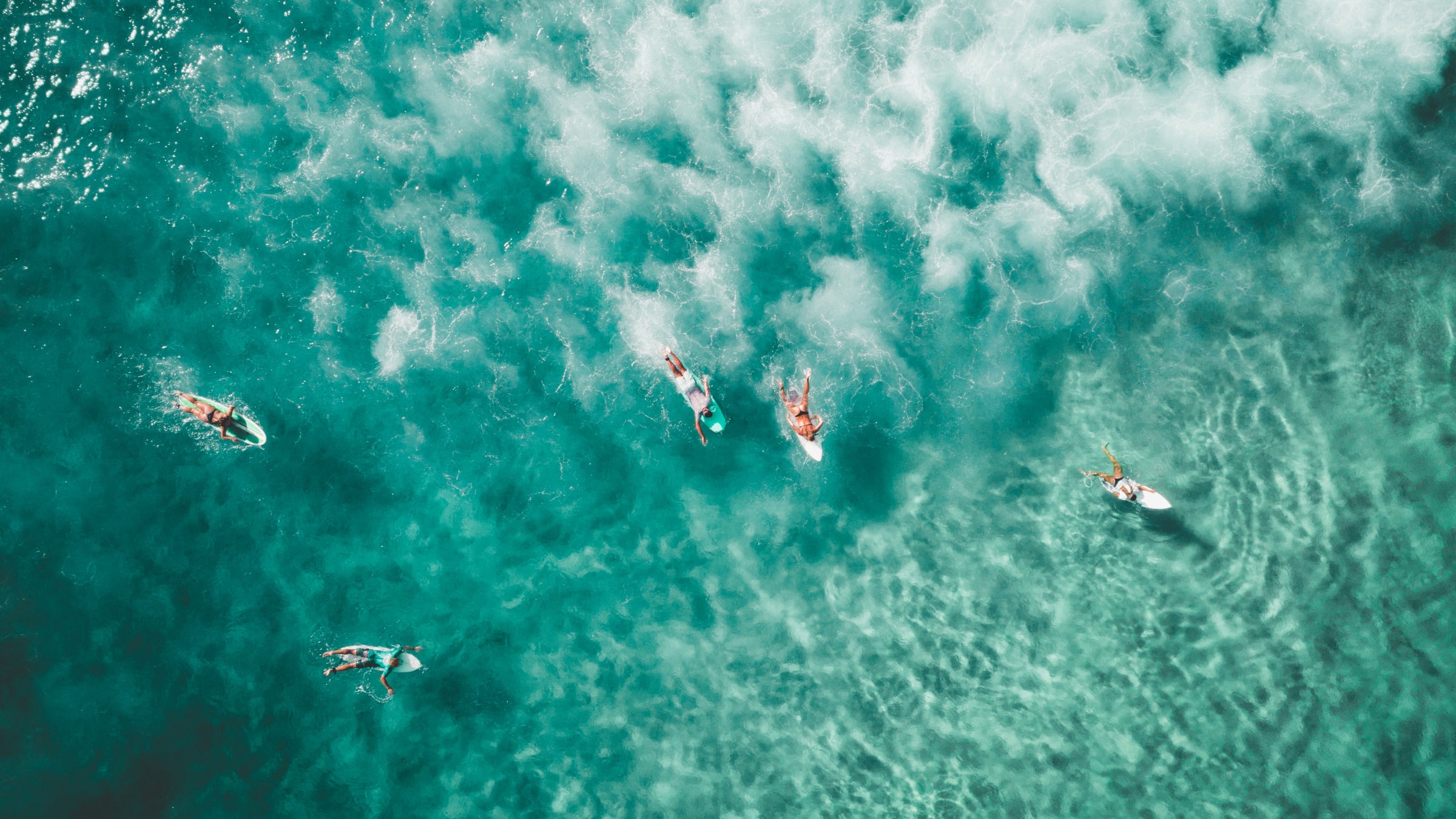 Surfers in a line up with crashing waves