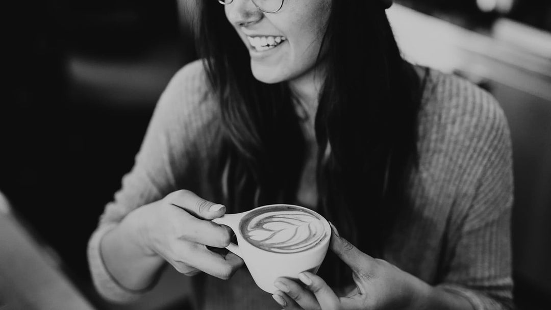Black and white photo of woman drinking latte