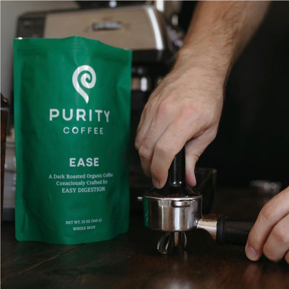 Hand tamping down freshly ground Purity coffee beans into espresso machine